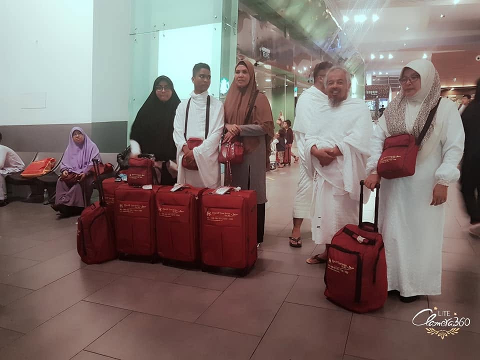 Peserta bersama bagasi merah di terminal lapangan terbang